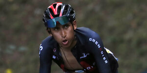 Rennradfahrer Bernal mit offenem Mund und Trikot beim Anstieg