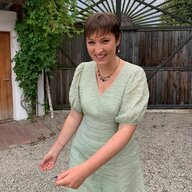 Eine junge Frau in einem hellgrünen Kleid mit kurzen brauen Haaren