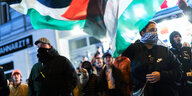 Protestierende Menschen mit Palästinenserfahnen