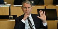 Björn Höcke, AfD-Fraktionschef, sitzt im Plenarsaal des Thüringer Landtag und hebt seine linke Hand
