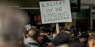 Protestierende mit einem Schild: Kalifat ist die Lösung